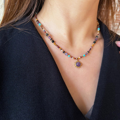 Close-up of purple amethyst and golden tiger eye beads on necklace