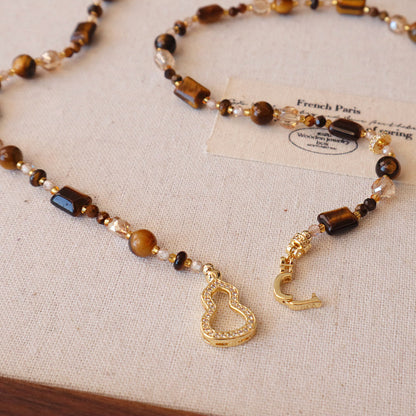 Detail of zircon-studded calabash charm on tiger eye sweater chain