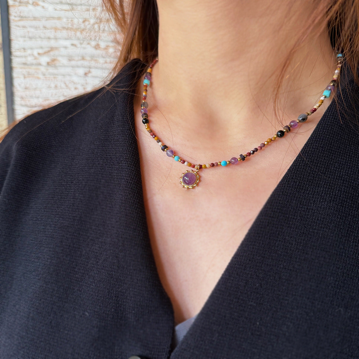 Detail of mixed gemstone necklace showing amethyst and tiger eye