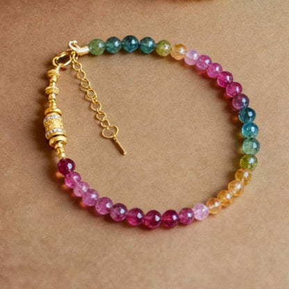 Candy-colored tourmaline bracelet with gold-plated mantra bead