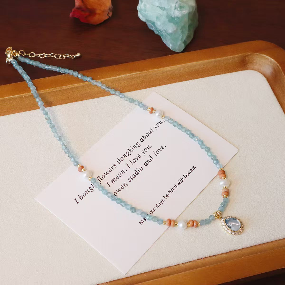 Close-up of aquamarine heart pendant with freshwater pearl accents