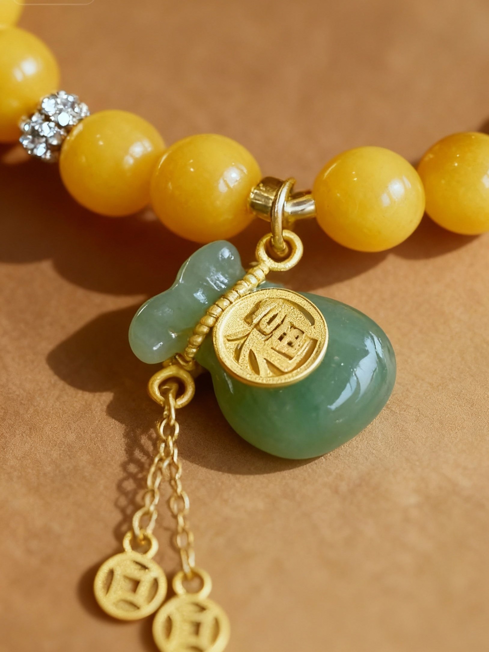 Detail of Hetian jade fortune pouch charm on amber bracelet