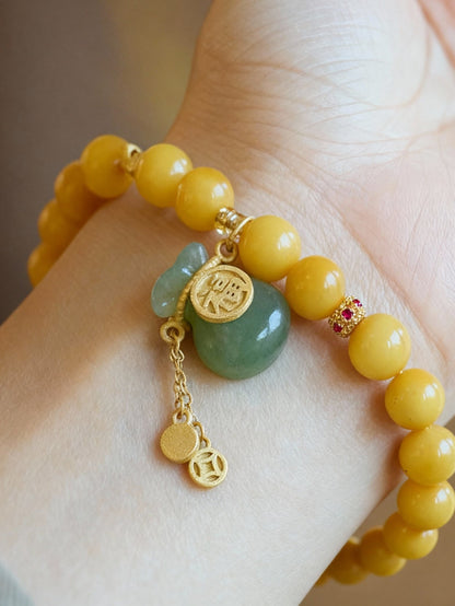 Close-up of amber beads with jade fortune pouch pendant