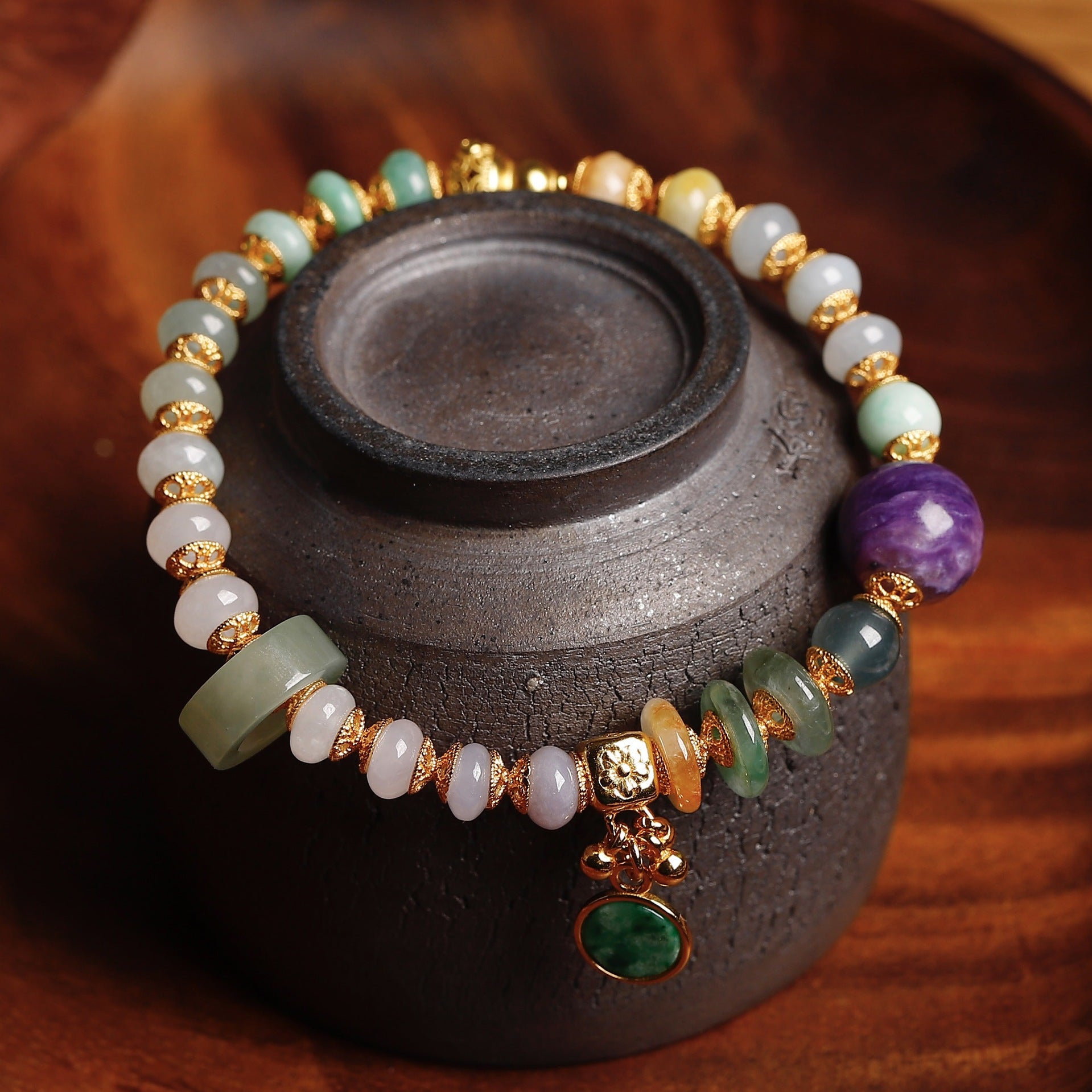 Natural charoite bead with deep violet swirling patterns as centerpiece of handcrafted jadeite bracelet