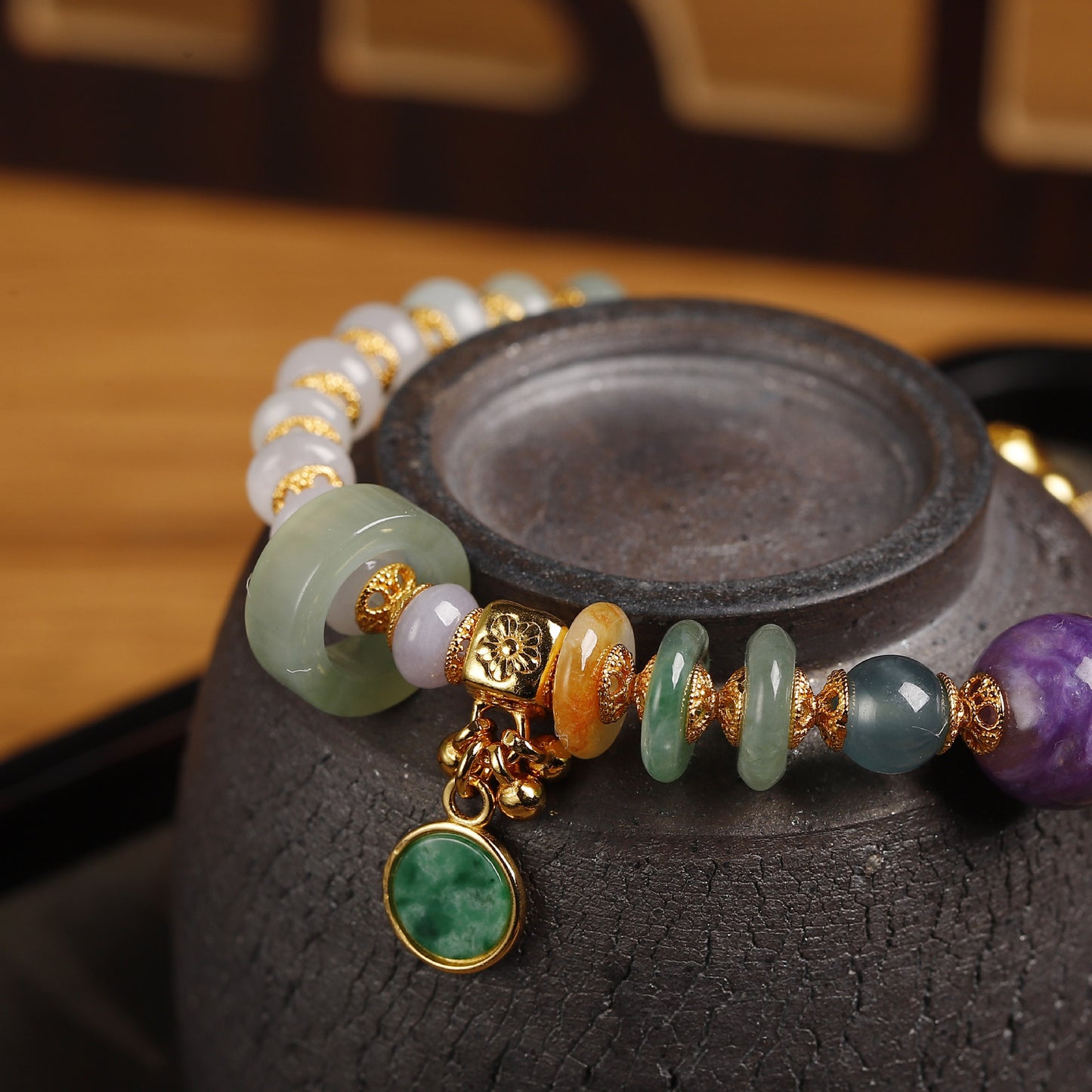 Natural charoite bead with deep violet swirling patterns as centerpiece of handcrafted jadeite bracelet