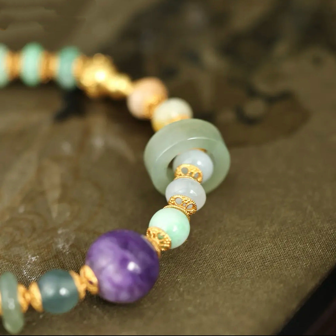 Close-up of natural tri-color jadeite abacus beads with gold-plated spacers, showing vibrant green translucency