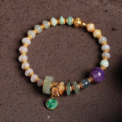 Natural charoite bead with deep violet swirling patterns as centerpiece of handcrafted jadeite bracelet