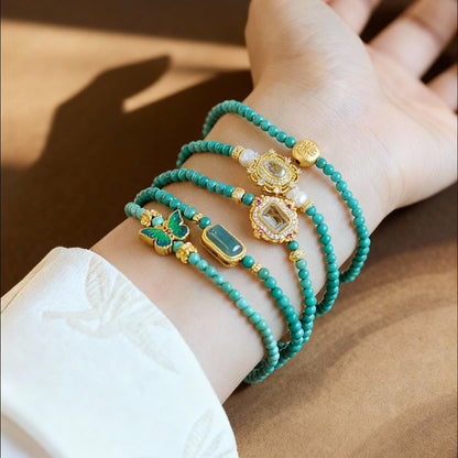 Natural turquoise bracelet featuring enamel butterfly charm