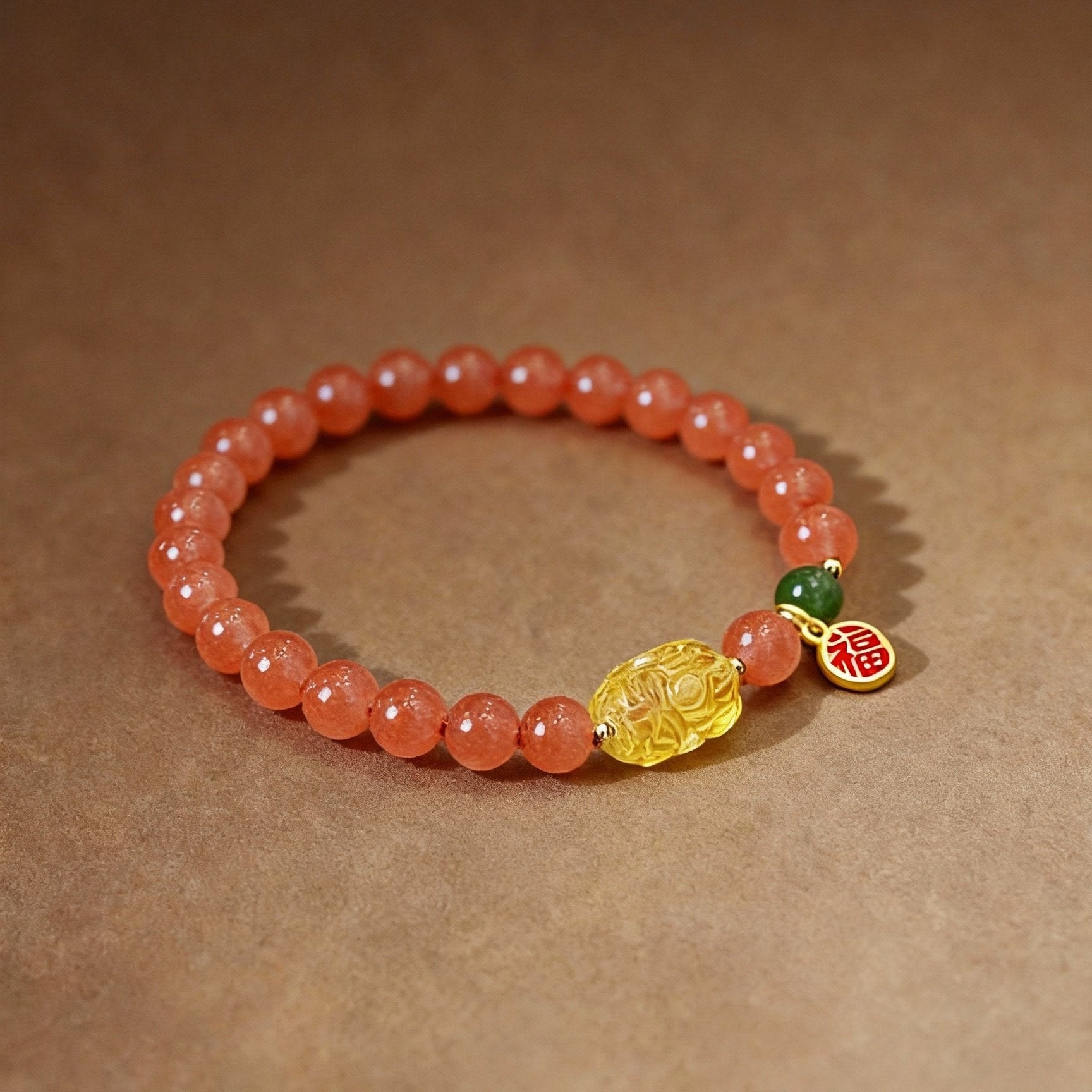 Close-up of red nanhong agate beads with amber Pixiu charm