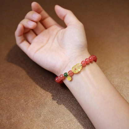 Detail of cherry-red agate bracelet with amber Pixiu pendant