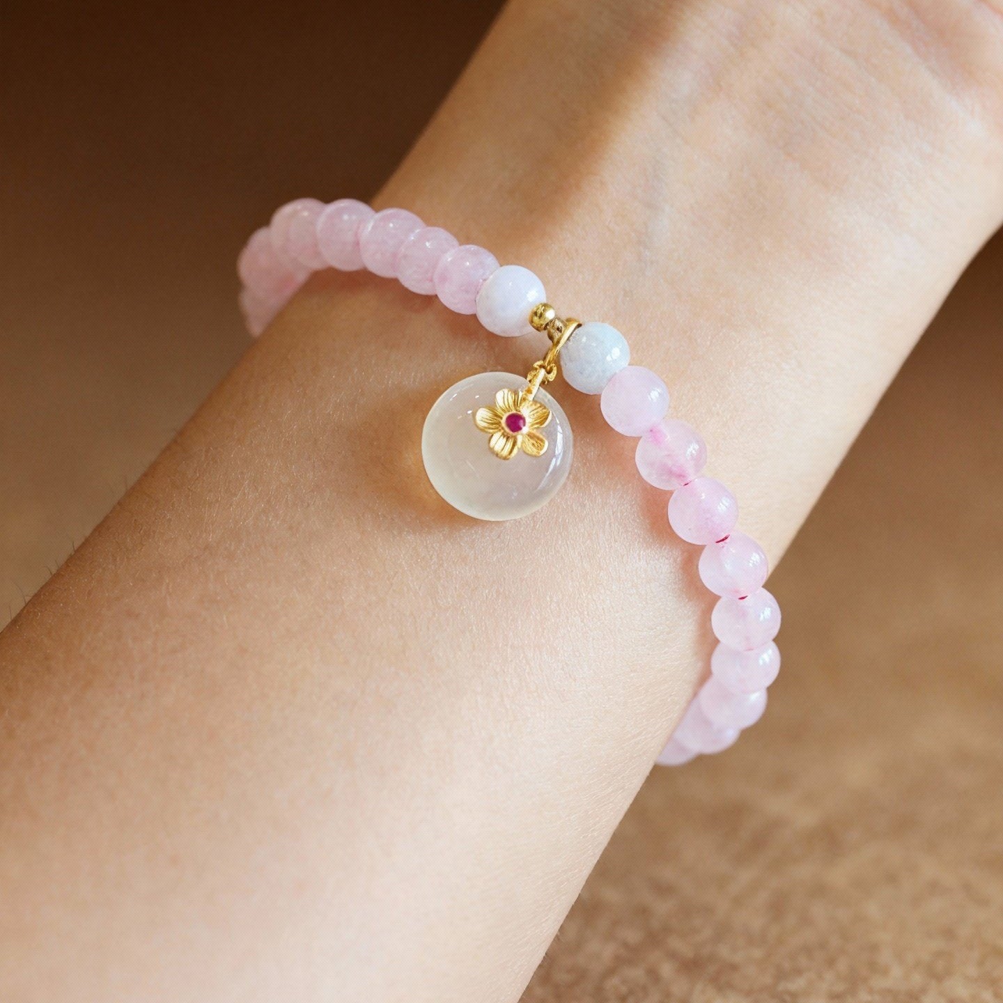 Detail of pink and white beaded bracelet with jade and crystal