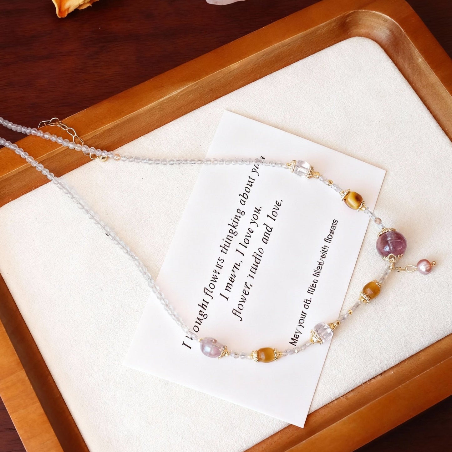 Close-up of clear quartz, purple amethyst and pearl beaded necklace