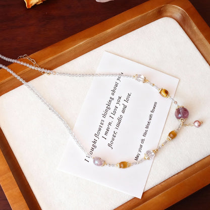 Close-up of clear quartz, purple amethyst and pearl beaded necklace