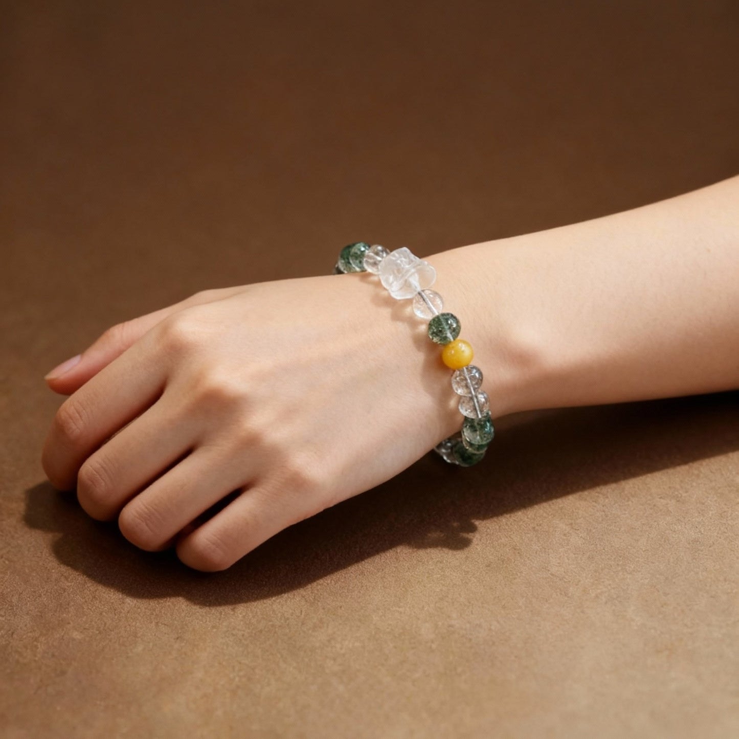 Detail of yellow agate lion dance charm on phantom quartz bracelet