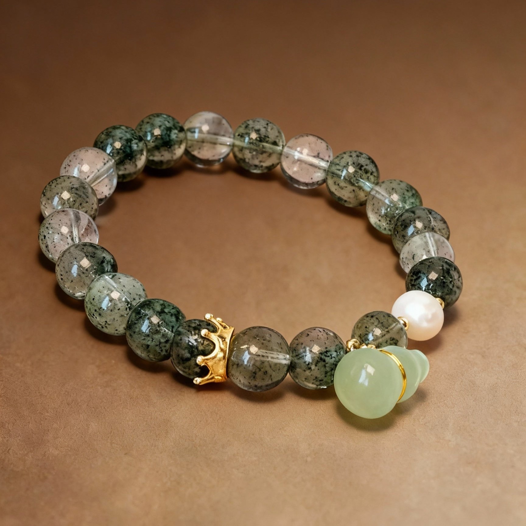 Detail of serpentine jade gourd pendant on phantom quartz bracelet
