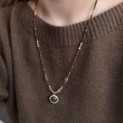 Tiger eye and mother-of-pearl sweater chain showing natural materials