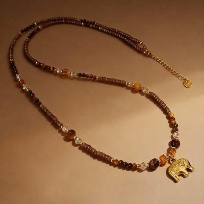 Detail of elephant pendant charm on tiger eye sweater chain