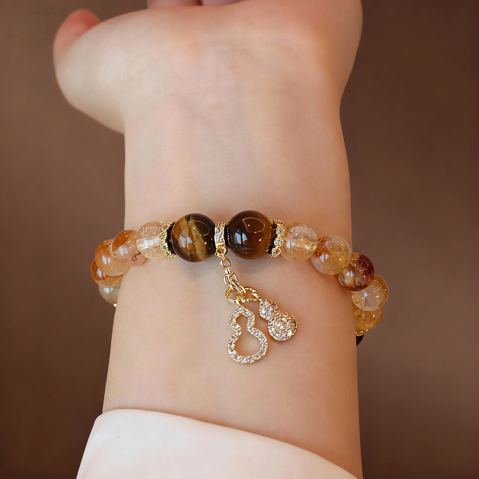 Golden crystal bracelet showing citrine, tiger eye and gourd pendant
