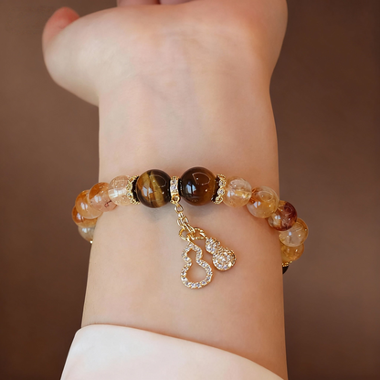 Golden crystal bracelet showing citrine, tiger eye and gourd pendant
