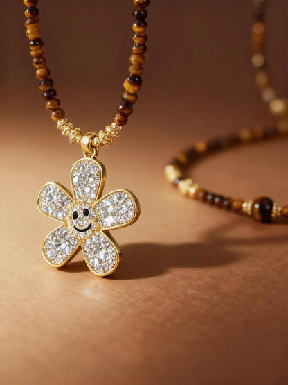 Close-up of tiger eye beads with sparkling zircon flower pendant