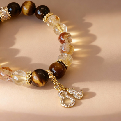 Close-up of rutilated citrine and tiger eye beads with gourd pendant
