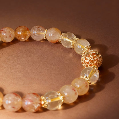 Golden rutilated quartz bracelet showing metal ball bead detail
