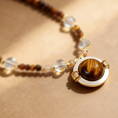Detail of mother-of-pearl shell pendant on tiger eye sweater chain